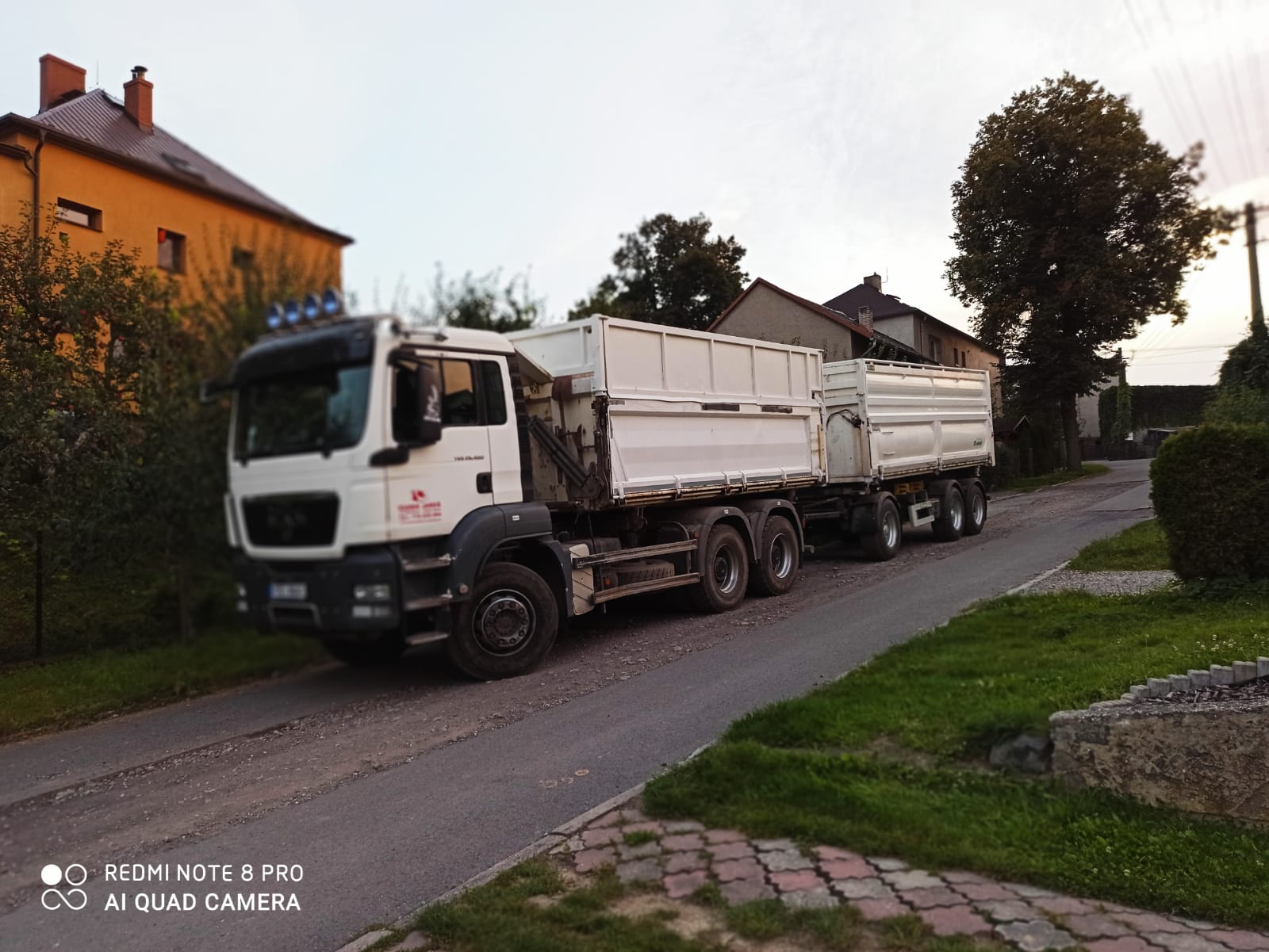 Bílý nákladní vůz při přepravě materiálu